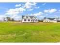 Beautiful white house with a well-manicured lawn, complemented by bright blue skies and scattered clouds at 3538 Good Luck Rd., Aynor, SC 29511