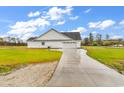 Spacious three-car garage featuring white siding, black roof, and long concrete driveway at 3538 Good Luck Rd., Aynor, SC 29511