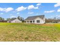 Back exterior of a white home featuring a covered porch perfect for relaxing or entertaining guests at 3538 Good Luck Rd., Aynor, SC 29511