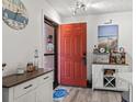Bright entryway featuring a striking red door, beach-themed decor, and a stylish sideboard and bar cabinet at 3015 Old Bryan Dr. # 13-1, Myrtle Beach, SC 29577