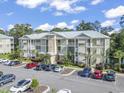 Condo complex with ample parking, well-maintained landscaping, and balconies on a bright sunny day at 130 Puffin Dr. # 1-C, Pawleys Island, SC 29585