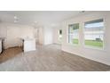 Open-concept living space with bright windows, wood-look flooring, and a view of the kitchen at 230 Ashworth Dr., Tabor City, NC 28463