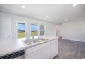 Kitchen island with stainless steel sink, dishwasher, and views of the backyard at 244 Ashworth Dr., Tabor City, NC 28463