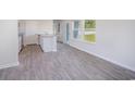 Open-concept kitchen and living area featuring gray wood-look floors and natural light at 244 Ashworth Dr., Tabor City, NC 28463
