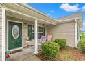 Inviting covered porch with comfortable seating, perfect for relaxing at 719 American Beech St., Loris, SC 29569