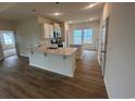 Bright, modern kitchen with white cabinets, quartz countertops, stainless appliances, and island at 582 Honeyhill Loop, Conway, SC 29526