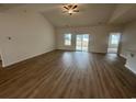 Open-concept living room with wood flooring, vaulted ceiling, and access to the patio at 582 Honeyhill Loop, Conway, SC 29526
