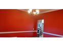 Red-painted dining room with crown molding and a view into the kitchen at 78 Joys Pl., Andrews, SC 29510