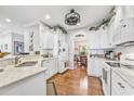 Bright kitchen with white cabinetry, stainless steel appliances, and hardwood floors at 1296 Foxtail Dr., Longs, SC 29568