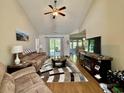 Inviting living room with vaulted ceilings, a ceiling fan, and a view into the adjacent kitchen at 209 Foxpath Loop, Myrtle Beach, SC 29588