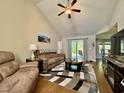 Bright living room with a ceiling fan, sliding glass doors, and a view of the kitchen and breakfast bar at 209 Foxpath Loop, Myrtle Beach, SC 29588