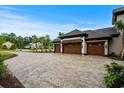 Expansive three-car garage with brick accents and a wide cobblestone driveway at 372 Chamberlin Rd., Myrtle Beach, SC 29588