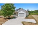 Inviting home featuring a well-manicured lawn, attached garage, and a long driveway at 7913 E Highway 19, Loris, SC 29569