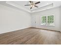 Bright living room featuring hardwood floors, large windows, and modern ceiling fan at 7913 E Highway 19, Loris, SC 29569