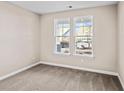 Bright, carpeted bedroom with two windows offering pleasant neighborhood views at 5032 Cambria Ct., Little River, SC 29566