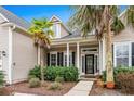 Close-up of front porch and door with decorative glass, columns, and landscaping at 621 Elgin Ct., Myrtle Beach, SC 29579