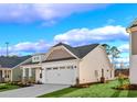 Side view of a charming home featuring a well-manicured lawn and an attached two-car garage at 5028 Cambria Ct., Little River, SC 29566