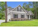 Stylish home featuring gray siding, black shutters, a two-car garage, and lush green landscaping at 2612 Old Charleston Rd., Georgetown, SC 29440