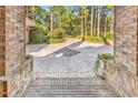 Beautiful patterned driveway viewed from the covered front porch of this elegant brick home, inviting exploration at 89 Gleneagle Ln., Pawleys Island, SC 29585