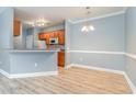 Open concept dining room with wood-look flooring, chair rail, and modern light fixture at 2073 Silver Crest Dr. # 4 D, Myrtle Beach, SC 29579