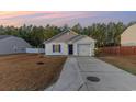 Dusk view of a cozy single-story home with a manicured lawn and an attached one-car garage at 684 Trap Shooter Circle, Longs, SC 29568