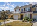 Inviting yellow home boasts a private balcony, manicured lawn and attached garage at 206 Mossy Stone Ct. # 1605, Murrells Inlet, SC 29576