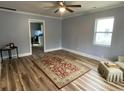 Inviting living room with wood floors, light blue walls, ceiling fan and a bright window at 416 S Magnolia Ave., Andrews, SC 29510