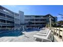Condo pool with inviting lounge chairs and community amenities for relaxing in style at 1101 Possum Trot Rd. # B302, North Myrtle Beach, SC 29582