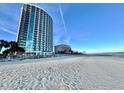 A wide shot of the building taken from the beach showing light sand and a blue sky at 107 S Ocean Blvd. # 808, Myrtle Beach, SC 29577