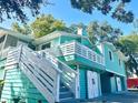 Charming coastal home featuring a spacious deck, white railings, and a vibrant turquoise exterior at 3936 Murrells Inlet Rd., Murrells Inlet, SC 29576