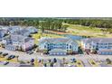 Aerial view of condos, parking, and golf course with pond and trees at 4879 Dahlia Ct. # 204, Myrtle Beach, SC 29577