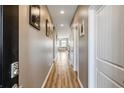 Hallway with hardwood floors leading to a living area, and several white doors on each side at 263 Red Maple Loop, Longs, SC 29568