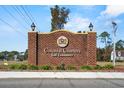 Entrance to Colonial Charters Golf Community, featuring a brick sign and well-maintained landscaping at 2169 Wedgewood Dr., Longs, SC 29568