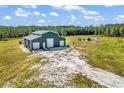 A large barn with multiple garage doors sits on a grassy lot surrounded by forest at 7299 Cartrette Rd., Aynor, SC 29511