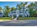 Charming two-story home featuring a well-manicured lawn, a paved walkway, and black shutters at 121 Grand Palm Ct., Myrtle Beach, SC 29579