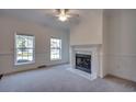 Cozy living room features a fireplace, neutral carpet, and windows offering natural light at 121 Grand Palm Ct., Myrtle Beach, SC 29579