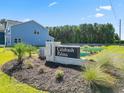 Calabash Palms community sign with lush landscaping, blue house, and pond in a desirable neighborhood at 794 Nw Palm Frond Way # 48, Calabash, NC 28467