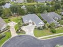 An aerial view of a neighborhood showcasing manicured lawns, mature trees, and a tranquil pond at 116 Ocean Sands Ct., Myrtle Beach, SC 29579