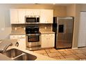 Well-equipped kitchen featuring stainless steel appliances, white cabinets, and tile flooring at 156 Weeping Willow Dr., Myrtle Beach, SC 29579