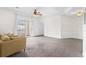 Bright, carpeted living room with neutral walls, ceiling fan, and balcony access at 2241 Waterview Dr. # 437, North Myrtle Beach, SC 29582