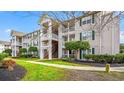 Exterior view of condo building featuring private balconies, green shutters, and well-maintained landscaping at 3735 Block House Way # 113, Myrtle Beach, SC 29577