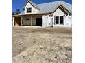 New home under construction featuring Tyvek wrap, framed windows, and a partial view of the two-car garage at 8001 Mcsweeney Ct., Myrtle Beach, SC 29588