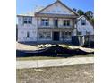 Two-story house under construction showing Tyvek wrap, window frames, and a dumpster on the side at 8001 Mcsweeney Ct., Myrtle Beach, SC 29588