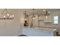 Modern kitchen with white cabinets, quartz countertops, pendant lighting, and stainless steel appliances at 8652 Farrier Dr., Myrtle Beach, SC 29588