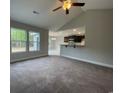 Open concept living room showcasing a vaulted ceiling, carpet floors, and a view into the adjacent kitchen area at 910 Padgett Lane, Conway, SC 29526