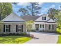 Charming single Gathering home with a light exterior, dark shutters, meticulous landscaping, and concrete drive at 2588 Lake Vista Dr., Little River, SC 29566