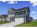 Charming two-story home with a spacious front yard, two car garage, and inviting covered porch at 5015 Cambria Ct., Little River, SC 29566