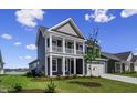 Charming two-story home with a spacious front yard, two car garage, and inviting covered porch at 5015 Cambria Ct., Little River, SC 29566