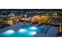 Community pool area at dusk features lounge seating and string lights above a lawn at 5015 Cambria Ct., Little River, SC 29566