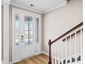 Bright foyer featuring a glass-paneled front door, hardwood floors, and a staircase with wood railing and white spindles at 5036 Cambria Ct., Little River, SC 29566